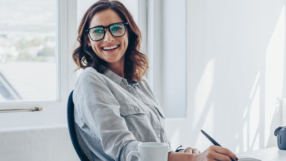 Image of a mortgage broker smiling sitting at her desk