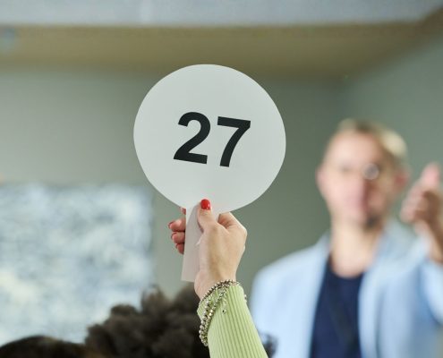 Person with the best auction strategy bidding at an auction