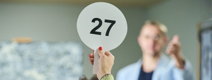 Person with the best auction strategy bidding at an auction